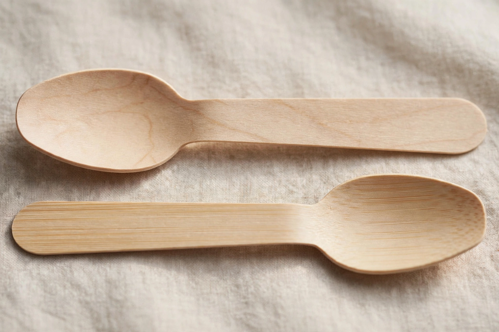 Close-up comparison of birch wood grain and bamboo texture on spoons